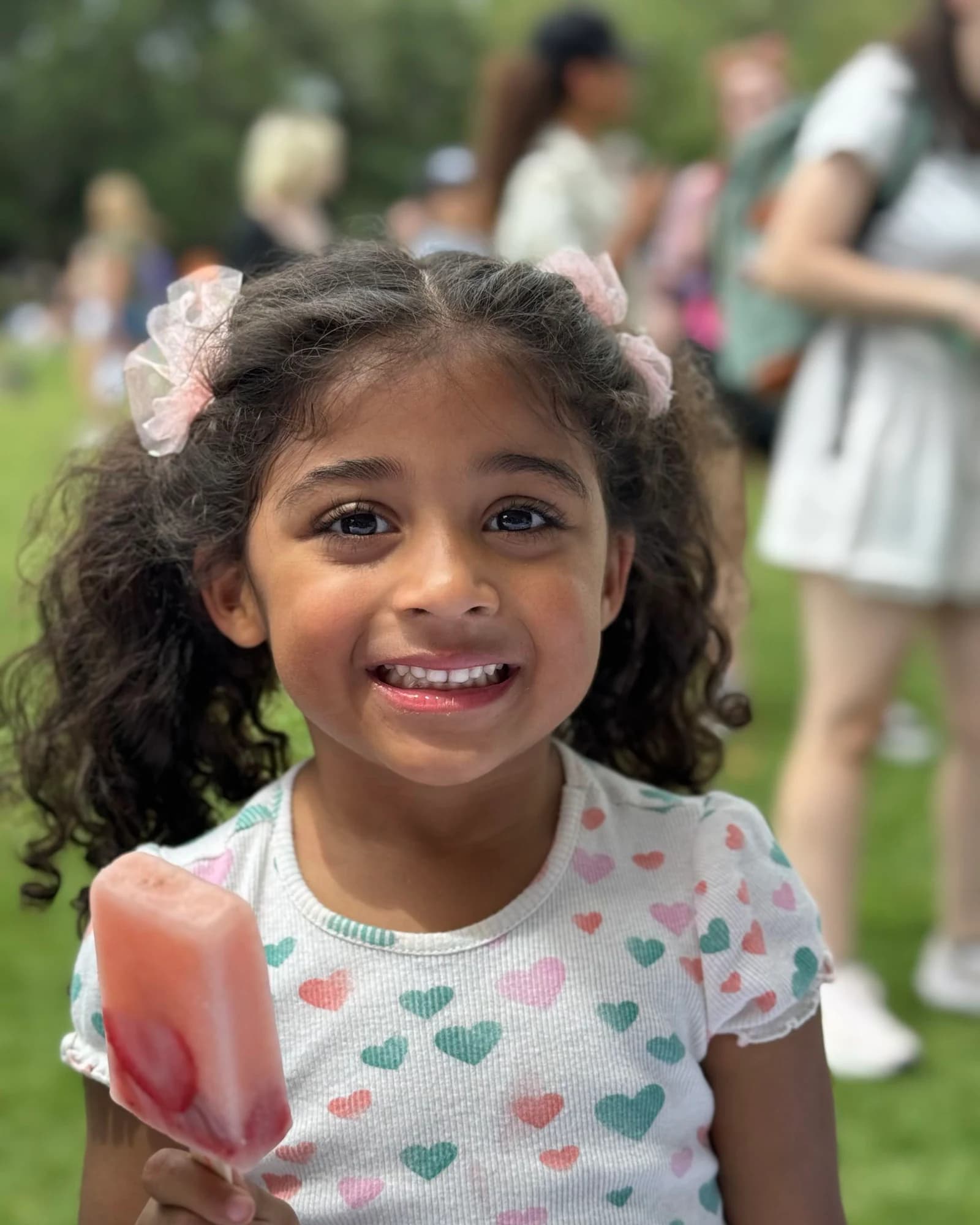 A smiling girl holding a Savannah Square Pops pop